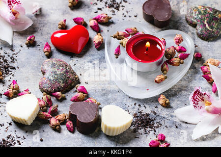 Bonbons de chocolat en forme de coeur avec un plateau sec et les orchidées roses pour la Saint Valentin. Banque D'Images