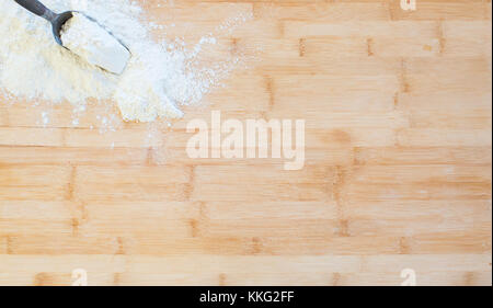 La farine se trouve dans un metal scoop sur une planche à découper en bois Banque D'Images