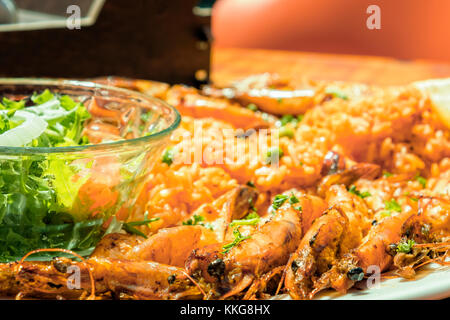 Gambas grillées plat avec de la salade verte et du riz au curry, servi dans un restaurant d'Afrique du Sud. Banque D'Images