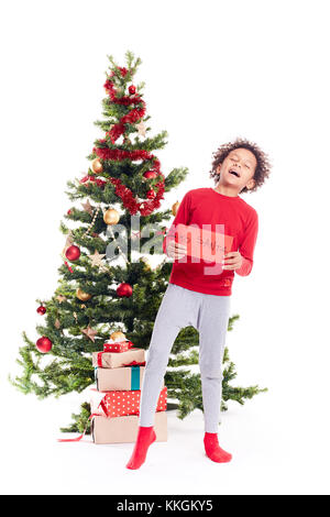 Mixed Race boy near Christmas Tree Banque D'Images