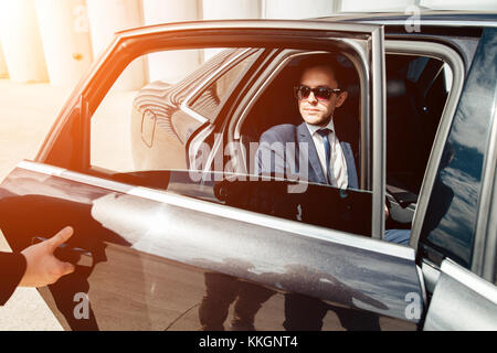 Portrait of businessman de l'ouverture de la porte de sa voiture Banque D'Images