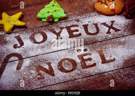 Libre d'une table en bois saupoudrée de sucre glace ou de farine où vous pouvez lire le texte joyeux Noel, joyeux Noël en français, d'un rouleau à pâtisserie, et s Banque D'Images