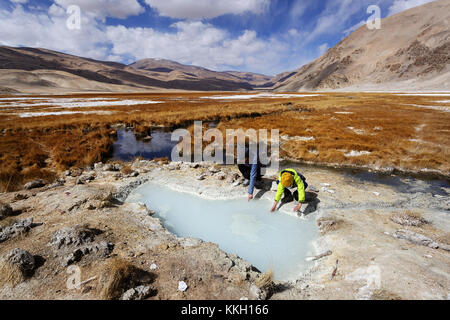 La mère et le fils de toucher de l'eau chaude d'un geyser dans la zone géothermique de Puga, le Ladakh, le Jammu-et-Cachemire, en Inde. Banque D'Images