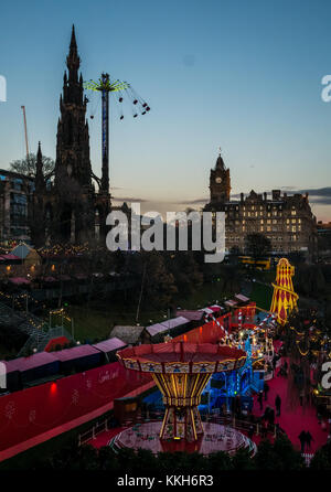 Edinburgh, Ecosse, Royaume-Uni, le 30 novembre 2017. La célébration de Noël Marché de Noël d'Édimbourg et de manèges forains, avec une star flyer en action près de Scott Monument situé sur Princes Street Gardens. Le centre-ville est éclairée avec des lumières colorées magnifique au coucher du soleil sur une soirée d'hiver Banque D'Images