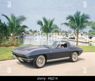 Photographie d'une Corvette Sting Ray 1964 de Chevrolet, mettant en valeur le design classique d'une voiture de sport américaine avec sa lunette arrière divisée distinctive, ses lignes de carrosserie élégantes et son puissant moteur V8. Le modèle 1964 est très apprécié des passionnés de voitures pour ses performances et son style. Banque D'Images
