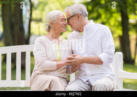 Happy senior couple sitting on bench at park Banque D'Images