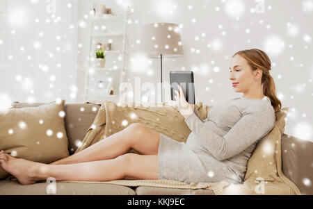 Smiling woman with tablet pc at home Banque D'Images