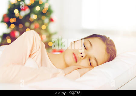 Girl sleeping in bed sur arbre de Noël Banque D'Images