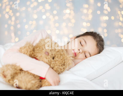 Girl sleeping with teddy bear toy au lit Banque D'Images