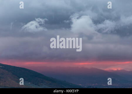 Certains profils de montagne au coucher du soleil, avec la couleur rouge très intense dans le ciel et de gros nuages Banque D'Images