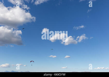 Trois para planeurs voler contre une profonde, ciel bleu, avec de gros nuages blancs Banque D'Images