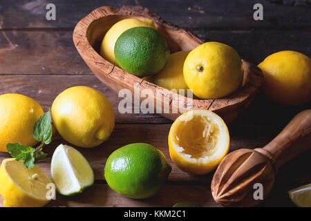 Tas d'ensemble et les tranches de citrons et limes bol en bois d'agrumes et de l'aléseur fond de bois Banque D'Images