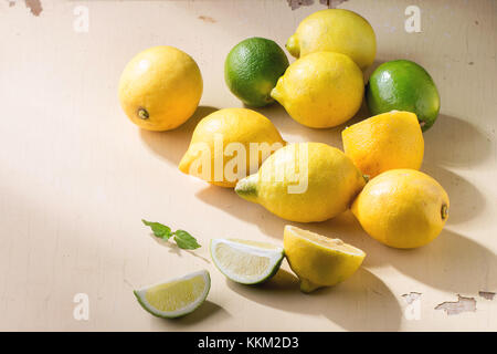 Tas d'ensemble et les tranches de citrons et limes sur fond de bois rustique. La lumière du soleil. Banque D'Images