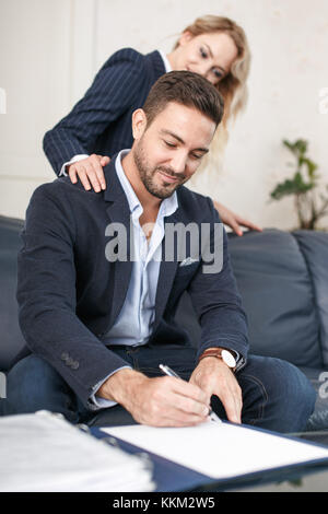 Jeune femme blonde rusé séducteur riche homme d'affaires à signer des documents, les gestionnaires de l'escroc Banque D'Images