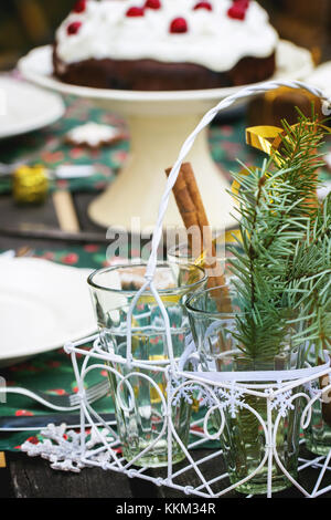 Réglage de la table de noël en plein air avec des bâtons de cannelle et chocolat Gâteau cerise. Banque D'Images