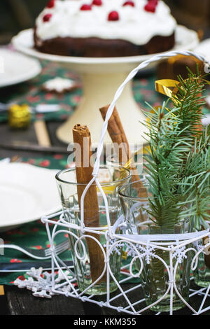 Réglage de la table de noël en plein air avec des bâtons de cannelle et chocolat Gâteau cerise. Banque D'Images