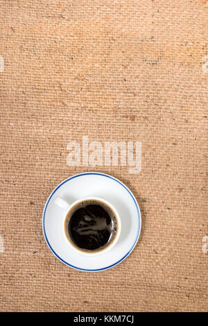 Vue de dessus du café expresso sur un fond en tissu de jute. Banque D'Images