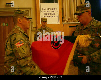 L'viv, Ukraine - le colonel Dennis Deeley, le groupe multinational interarmées - Ukraine, commandant du commandement et le Sgt. Le major Thomas Ciampolillo uncases la 27e Brigade d'infanterie couleurs l'équipe de combat au cours d'un JMTG-U cérémonie de transfert d'autorité ici 22 novembre. Au cours de la cérémonie Des soldats de la Garde Nationale de New York's 27th Infantry Brigade Combat Team (IBCT) a pris le commandement de l'JMTG-U de la Garde nationale de l'Oklahoma's 45th IBCT, qui ont été en Ukraine depuis janvier. (U.S. Photo de l'armée par le Sgt. Alexander Recteur) Banque D'Images