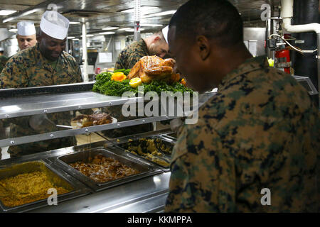 Le Sgt. Le Major Jeffrey A. Young, sergent-major de la 26e Marine Expeditionary Unit (MEU) sert de marine pendant le dîner de Thanksgiving à bord du navire d'assaut amphibie Iwo Jima (DG 7), dans l'Océan Atlantique le 23 novembre 2017. Les Marines et les marins de la MEU a pris une pause de l'unité de formation composite combinée (Exercice COMPTUEX) opérations pour fêter Thanksgiving avec un souper à la dinde traditionnelle. (U.S. Marine Corps photo par le Cpl. Jon Sosner) Banque D'Images