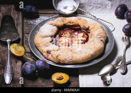 Galette gâteau aux prunes, servi dans vintage plaque métallique plus vieille table en bois. voir la série Banque D'Images