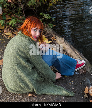 Belle jeune fille rousse dans le parc à l'automne chez les canards