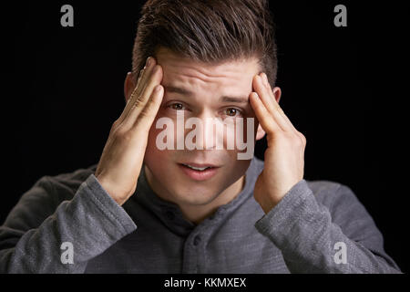 Portrait d'un jeune homme blanc inquiète holding head Banque D'Images