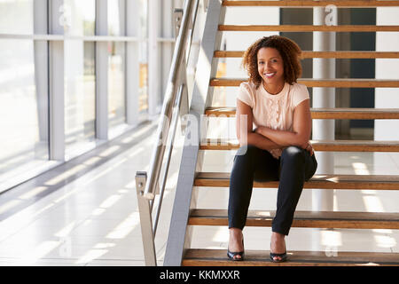 Portrait of a smiling woman sitting on stairs Banque D'Images