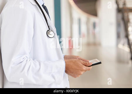 Mid section of doctor using tablet computer in corridor Banque D'Images