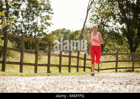 Healthy Senior Woman Enjoying courir dans la campagne Banque D'Images