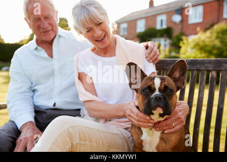 Couple sur banc de jardin avec Animal Bouledogue Français Banque D'Images