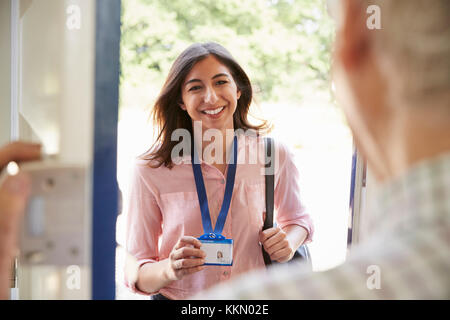 Man porte avant l'ouverture de jeune femme montrant une carte d'identité Banque D'Images