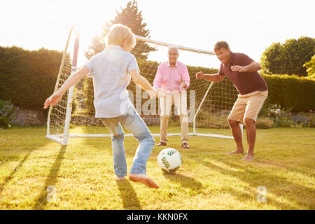 Trois générations d'une famille jouant au football Banque D'Images