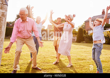 Multi generation family playing football dans le jardin Banque D'Images