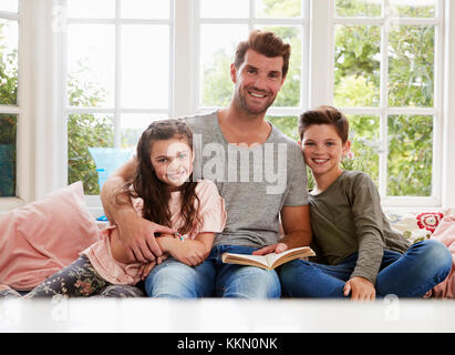 Portrait of Father Reading Book avec son fils et sa fille à la maison Banque D'Images