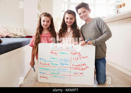 Portrait des enfants Faire de liste de tâches sur le tableau blanc à la maison Banque D'Images