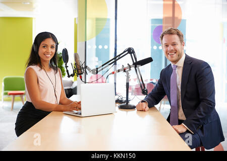 Intervieweuse et guest dans un sourire à l'appareil photo studio Banque D'Images