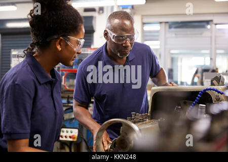 Montrant l'ingénieur apprenti chez les femmes Comment utiliser Lathe Banque D'Images