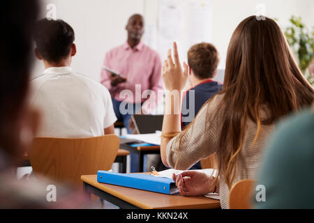 Vue arrière du Female College Student poser question dans la classe Banque D'Images