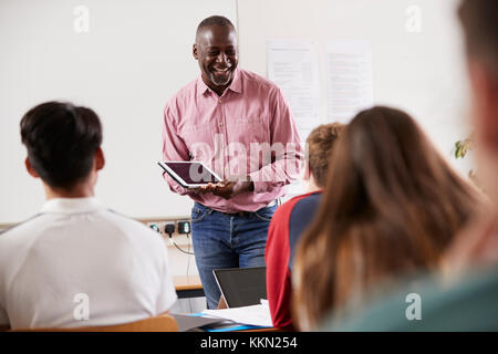 Collège masculin tuteur avec tablette numérique de classe d'enseignement Banque D'Images