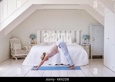 Femme au foyer à partir matin avec les exercices de yoga dans la chambre Banque D'Images