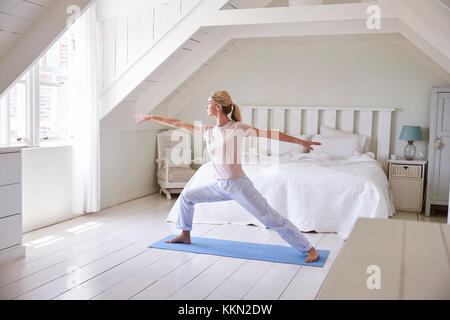 Femme au foyer à partir matin avec les exercices de yoga dans la chambre Banque D'Images