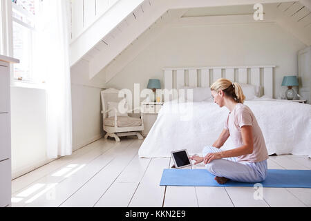 Woman with Digital Tablet App à l'aide de la méditation dans la chambre Banque D'Images