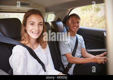 Portrait d'Enfants Adolescents in Back Seat of Car On Road Trip Banque D'Images