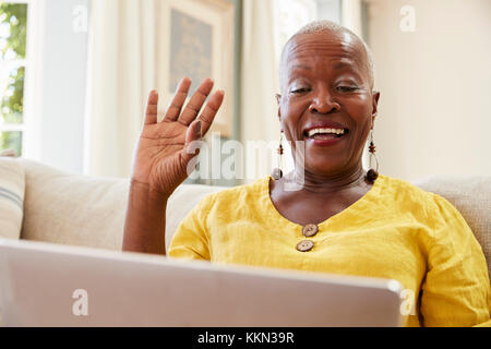 Senior Woman Using Laptop pour se connecter avec la famille pour l'appel vidéo Banque D'Images