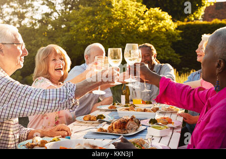 Groupe d'amis faire un toast au dîner en plein air Banque D'Images