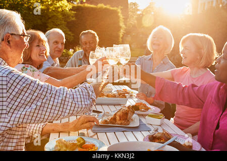 Groupe d'amis faire un toast au dîner en plein air Banque D'Images