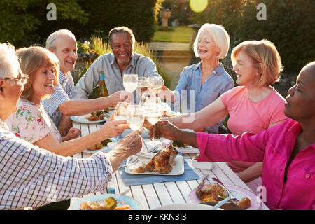 Groupe d'amis faire un toast au dîner en plein air Banque D'Images