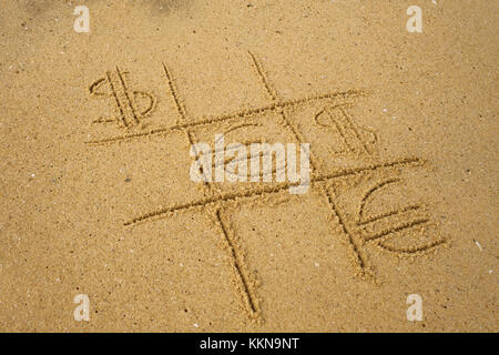 Le tic-tac-toe jouer avec jeu de symboles du dollar et l'euro sur le sable. Banque D'Images
