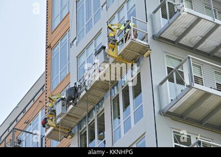 GREEN BAY, WISCONSIN - août 12, 2017 : nettoyage de vitres travaillant sur d'autres de l'extérieur d'un bâtiment dans un panier à Green Bay, Wisconsin Banque D'Images