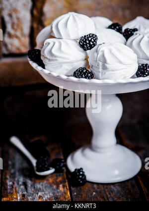 Cookies meringue witj mûres sur fond rustique Banque D'Images